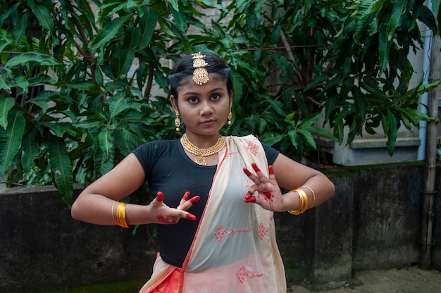 Zdjęcie nastoletnia dziewczyna praktykująca bharatnatyam w przyrodzie