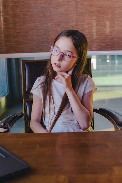 Nastoletnia dziewczyna w domu nauczania komputera. Dziewczyna w zamyśleniu wygląda przez okno. dystans