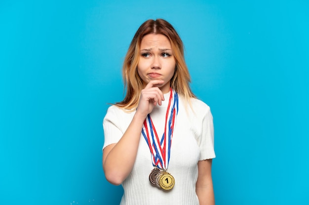 Nastoletnia dziewczyna z medalami na białym tle ma wątpliwości i myśli and