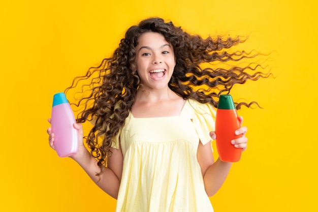 Nastoletnia dziewczynka pokazująca butelkę Szampon odżywki lub żel pod prysznic Kosmetyk do włosów Butelka na reklamę makiety kopia przestrzeń Podekscytowany nastolatek zadowolony zdumiony i uradowany emocjami