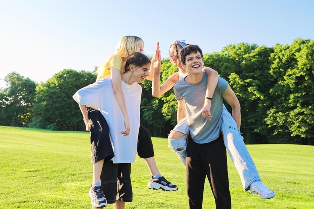 Nastoletnia młodzież ma zabawę w parku szczęśliwych roześmianych przyjaciół