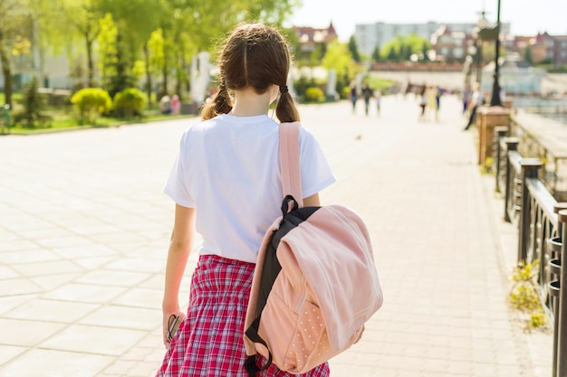 Zdjęcie nastoletnia studencka dziewczyna chodzi ulicę z plecakiem