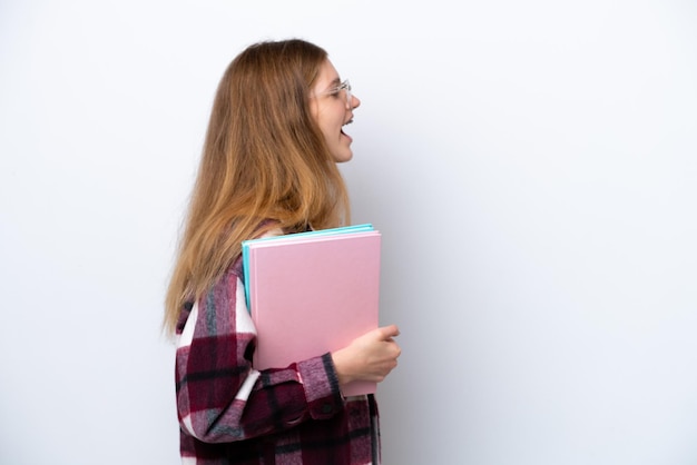 Nastoletnia studentka Rosyjska dziewczyna na białym tle śmiejąca się w pozycji bocznej