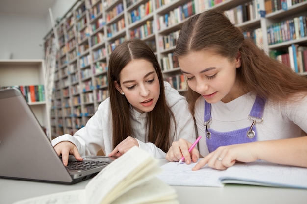 Nastoletnie dziewczyny uczące się razem w bibliotece