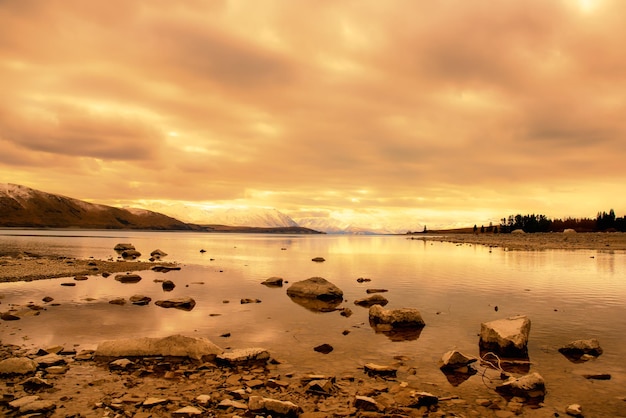 Nastrojowy pejzaż chmur uchwycony ze skalistego brzegu jeziora Tekapo
