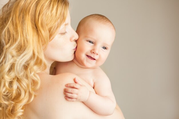 Naturalna blond kaukaska matka całuje szczęśliwe dziecko