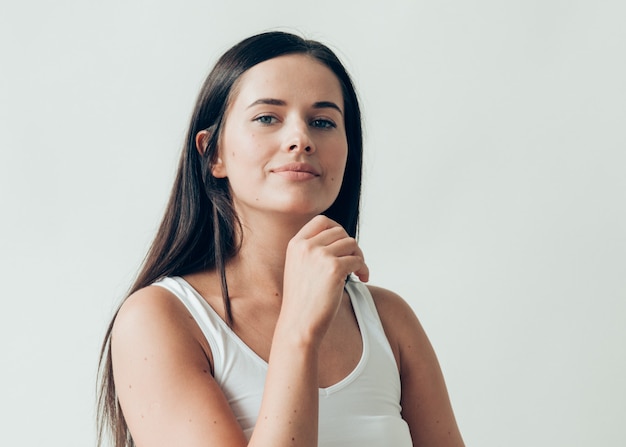 Naturalna brunetka kobieta długie włosy dorywczo makijaż. Strzał studio.