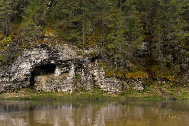 Naturalna jaskinia w wapiennym klifie na brzegu rzeki