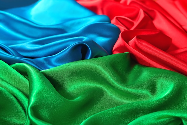 Naturalna tekstura tkaniny satynowej w kolorze niebieskim, czerwonym i zielonym