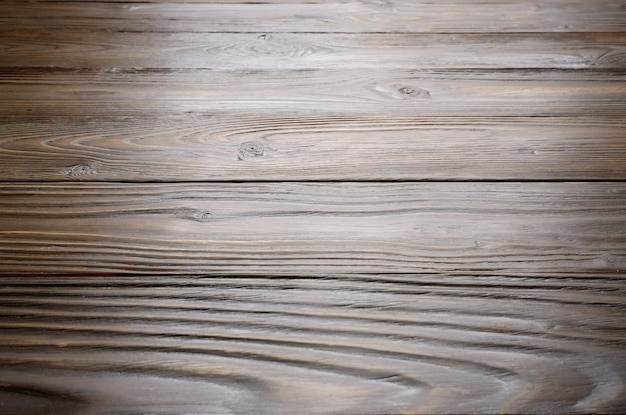 Naturalne ciemne drewniane teksturowane tło płasko ułożonych desek z wyblakłą zabytkową olejowaną powierzchnią