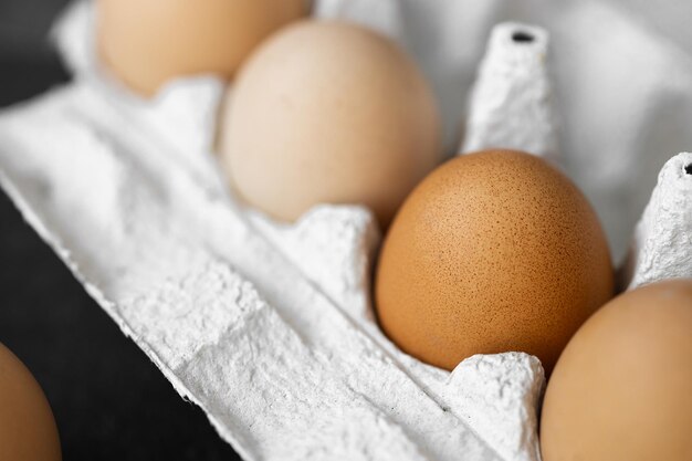 Naturalne jaja kurze w gospodarstwie na białym tle na ciemnym tle Koncepcja świąt wielkanocnych