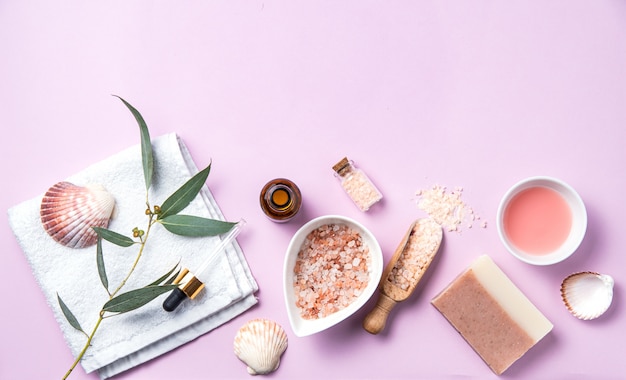 Naturalne kosmetyki organiczne z różową solą na różowym tle