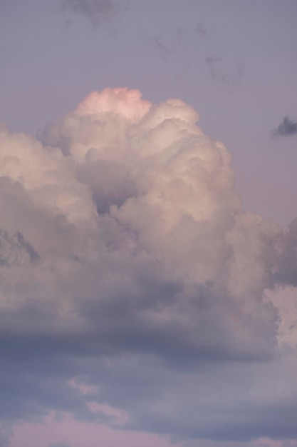 Naturalne słoneczne pomarańczowe i niebieskie tło nieba z pięknymi bufiastymi białymi chmurami cumulus