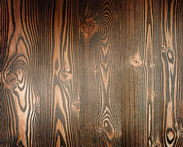 Naturalne tło ciemnobrązowej teksturowanej ściany z drewna