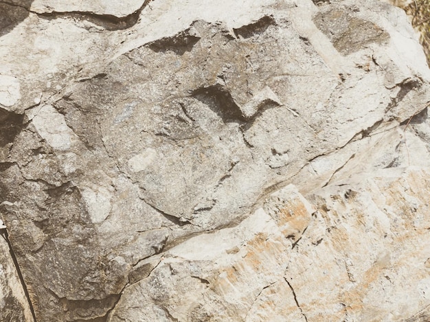 Naturalne tło Zbliżenie o krawędziach odrapanych pęknięć klifu Szarobrązowy kamień skała tekstura gór Vintage i wyblakły matowy kolor na przyciemnionym zdjęciu Koncepcja geologii wspinaczki górskiej lub ciężkiej pracy