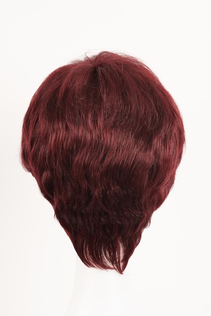 Naturalnie wyglądająca czerwona peruka bruneta na białej głowie manekina Ciemne włosy średniej długości na plastikowym uchwycie na perukę izolowanym na białym tle