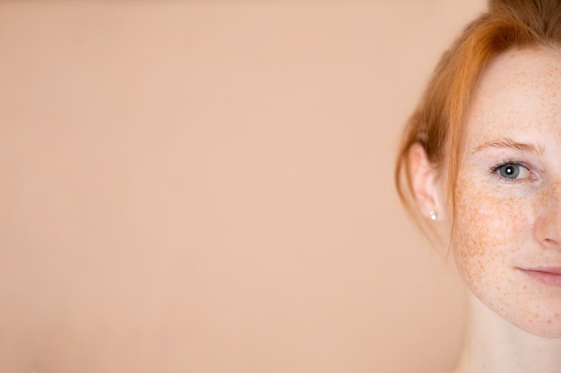 Naturalny portret pięknej młodej kobiety dziewczyny redhaired z piegami Nago makijaż pielęgnacji skóry Zbliżenie Beżowe tło miejsce na tekst