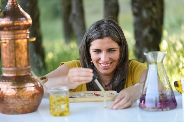 Naturopata pracujący na świeżym powietrzu z olejkami eterycznymi i kwiatami