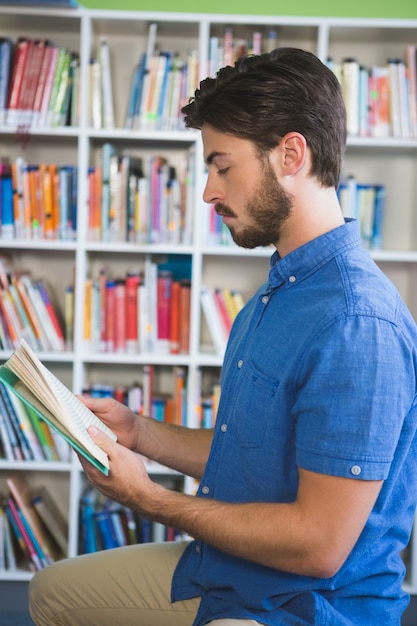 Nauczyciel czytanie książki w bibliotece