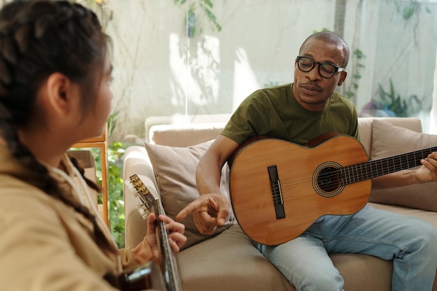 Nauczyciel gry na gitarze rozmawia z nastolatką