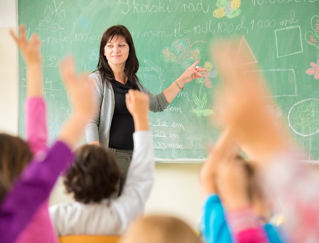 Nauczyciel pracuje z dziećmi w szkolnej klasie