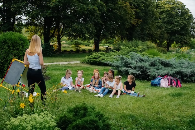 Nauczyciel prowadzi klasę dzieci w parku na świeżym powietrzu