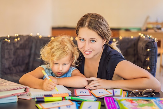 Zdjęcie nauczycielka korepetytorka do nauki domowej i nauczycielka przy stole lub mama i córka homeschooling