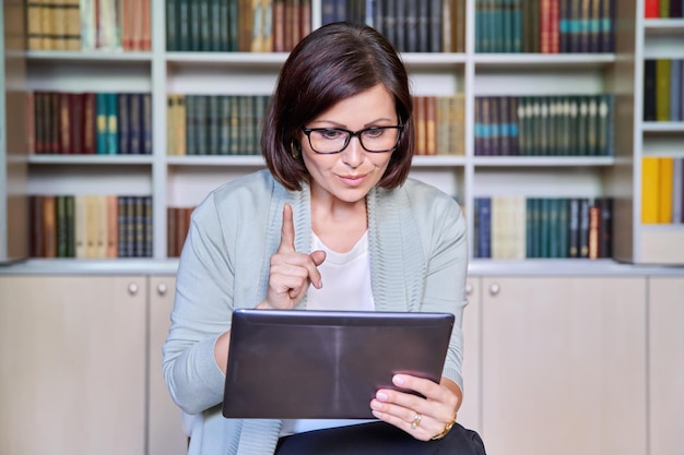 Nauczycielka Używająca Cyfrowego Tabletu Do Wideokonferencji Siedząca W Biurze Biblioteki