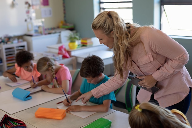 Zdjęcie nauczycielka z długimi blond włosami stojąca w klasie