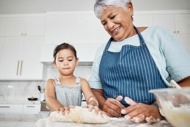Nauka gotowania ciasta i babcia z dziewczyną w kuchni do pieczenia deserów lub ciast Edukacja opieka nad rodziną i szczęśliwa babcia ucząca dziecko, jak piec wiązanie i wspólne spędzanie czasu