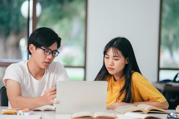 Nauka koncepcja edukacji i szkoły Młoda kobieta i mężczyzna uczący się do testu lub egzaminu Korepetycje z przyjaciółmi Kampus młodych studentów pomaga przyjacielowi nadrobić zaległości i uczyć się