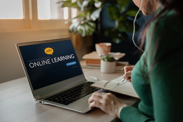 Nauka koncepcji online. Młoda kobieta za pomocą laptopa komputerowego do nauki e-learningu z Internetu w domu