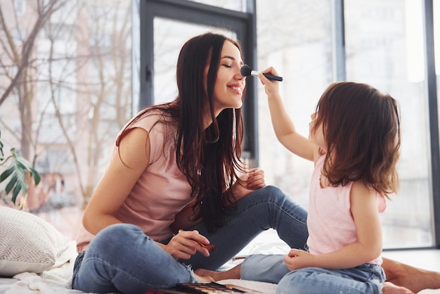 Nauka makijażu Młoda mama z córką spędzają wspólnie weekend w pokoju