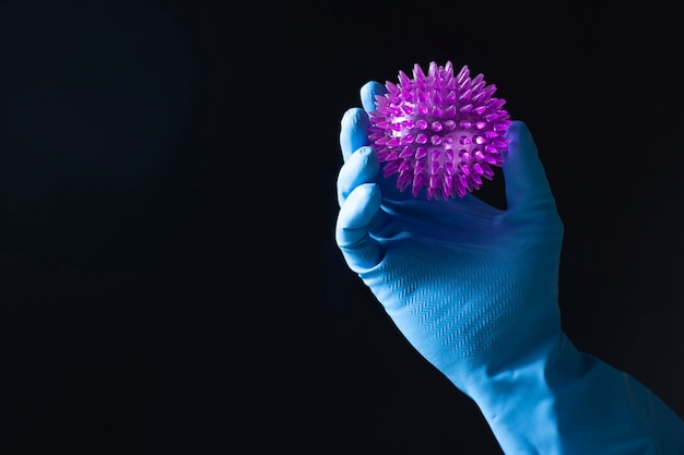 Naukowcy zajmujący się niebieskimi rękawiczkami trzymają wirusa korony, wywołując zarazki zaraźliwe