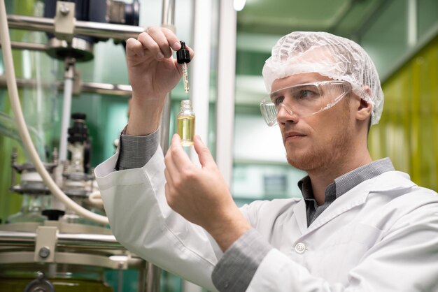 Zdjęcie naukowiec lub aptekarz wyciąg z oleju konopnego cbd do celów leczniczych w laboratorium