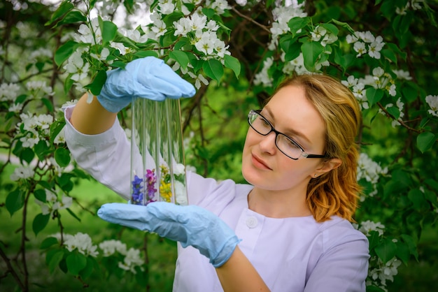 Naukowiec W Rękawiczkach Trzyma Probówki Z Płatkami Kwiatów W Ogrodzie, Tworzenie Perfum, Kosmetyki Naturalne