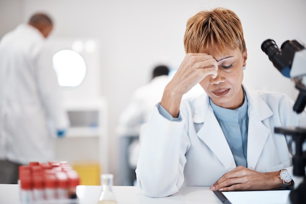 Zdjęcie naukowiec ze stresem i zmęczeniem głowy z kobietą przepracowaną nadgodzinami na przełom w nauce badania medyczne innowacje naukowe oraz wypalenie starszych kobiet i migrena w laboratorium