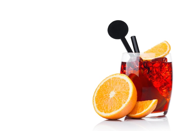 Negroni Cocktail w luksusowym szkle z kostkami lodu i plastrami pomarańczy ze słomką