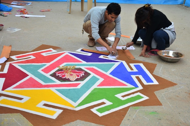 Nepalski rysunek wykonany symbol rangoli z farby proszkowej lub piaskowej dla nepalskich ludzi szanuje obrzęd modlitewny do bóstwa na festiwalu świateł na diwali na Thamel 3 listopada 2013 r. w Katmandu w Nepalu