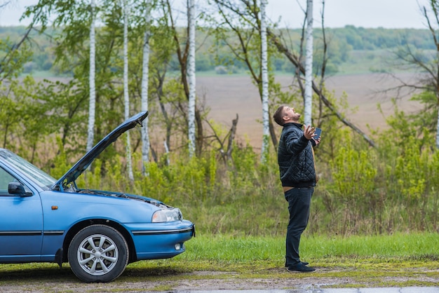 Zdjęcie nerwowy kierowca dzwoni do pomocy technicznej przez telefon