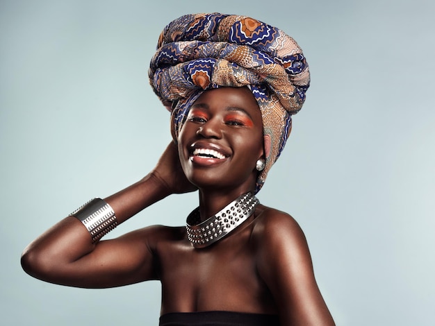 Nic tak nie dopełnia Twojego wyglądu jak stylowa chusta na głowę Studio ujęcie pięknej młodej kobiety w tradycyjnym afrykańskim chuście na szarym tle