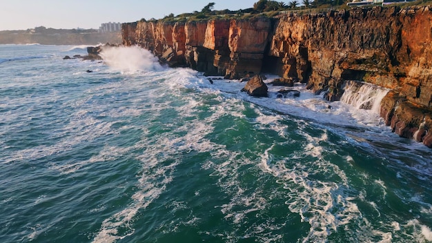 Niebezpieczne, szorstkie klify przybrzeżne, zmyte burzliwą wodą oceaniczną, widok z powietrza, ogromne fale.