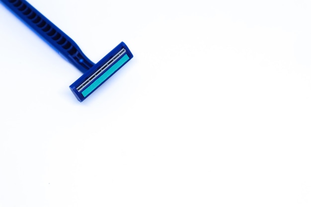 Zdjęcie niebieska brzytwa w rogu minimalistycznego białego tła z płaskim ujęciem, tryb poziomy