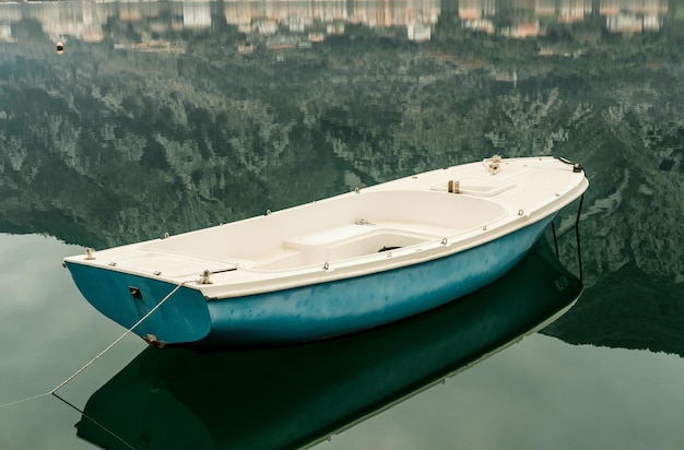Niebieska łódź w zatoce Adriatyku z górami w Czarnogórze Kotor