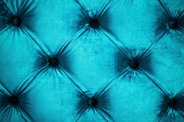 Niebieska luksusowa welurowa pikowana tapicerka sofy z guzikami elegancka tekstura i tło wystroju domu