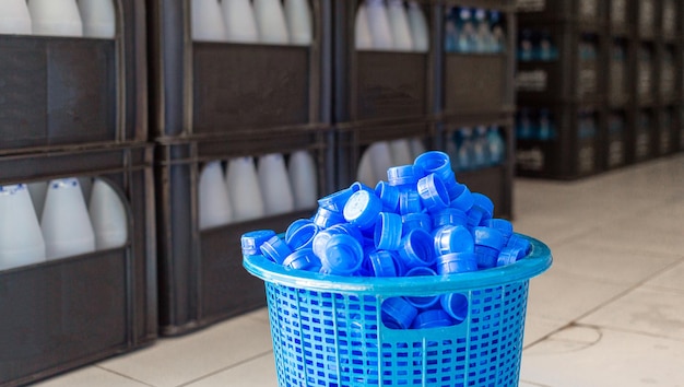 Niebieska plastikowa zakrętka do butelki z wodą Wiele stosów razem w plastikowym koszu w fabryce wody pitnej