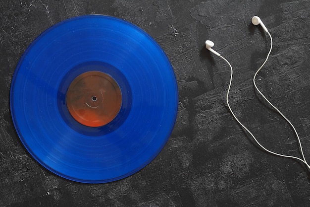 Niebieska płyta winylowa na czarnym tle w stylu retro