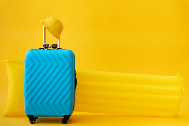 Niebieska walizka na żółtej powierzchni