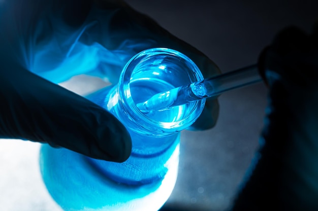 Niebieski eksperyment naukowy szklana probówkaNaukowcy z probówkami chemicznymi w laboratorium z płynnym szkłem dla