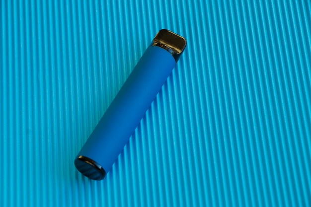 niebieski jednorazowy elektroniczny papieros na białym tle na niebieskim tle. nowoczesne palenie, vaping, elf bar